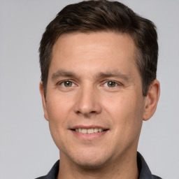 Joyful white young-adult male with short  brown hair and grey eyes