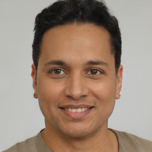 Joyful latino young-adult male with short  black hair and brown eyes