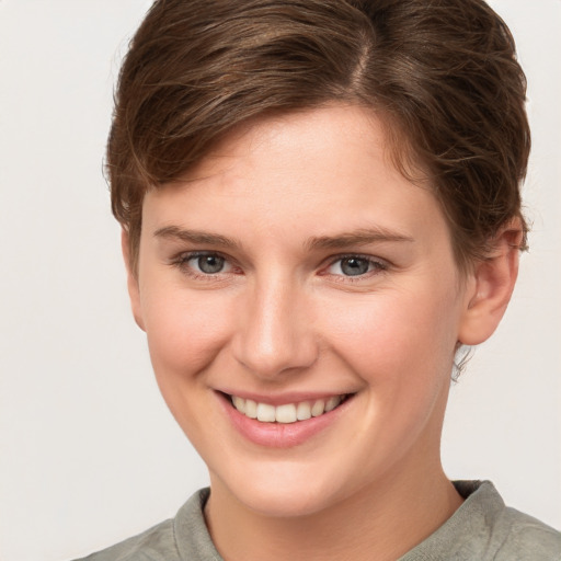 Joyful white young-adult female with short  brown hair and grey eyes