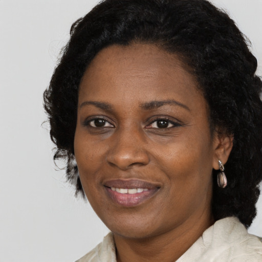 Joyful black adult female with long  black hair and brown eyes