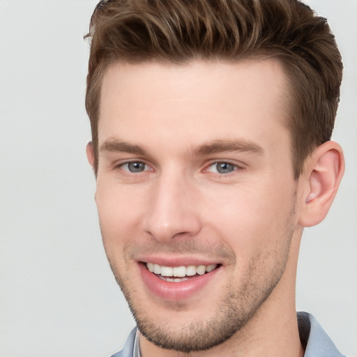 Joyful white young-adult male with short  brown hair and grey eyes