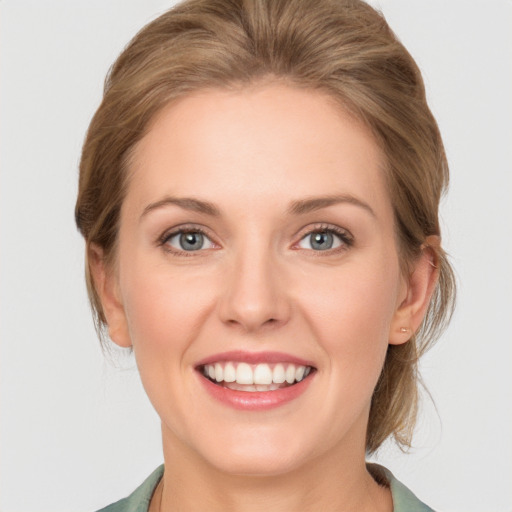 Joyful white young-adult female with medium  brown hair and blue eyes