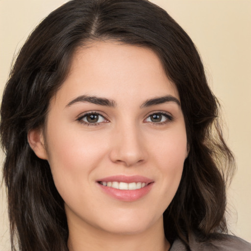 Joyful white young-adult female with long  brown hair and brown eyes