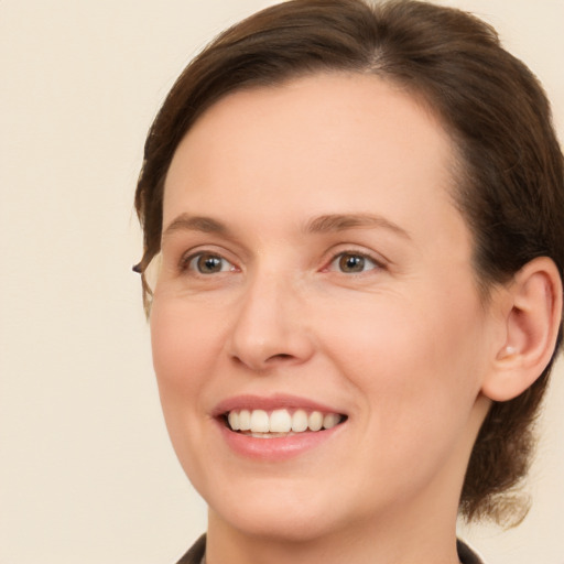 Joyful white young-adult female with short  brown hair and green eyes