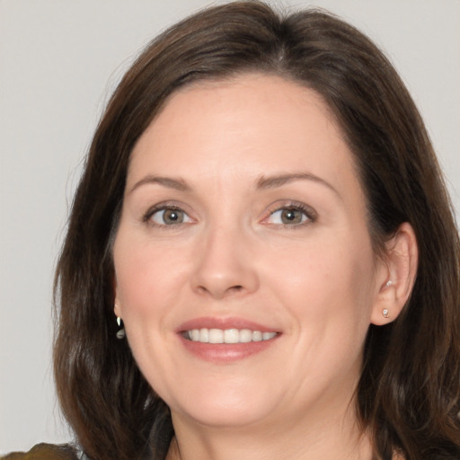 Joyful white adult female with medium  brown hair and brown eyes