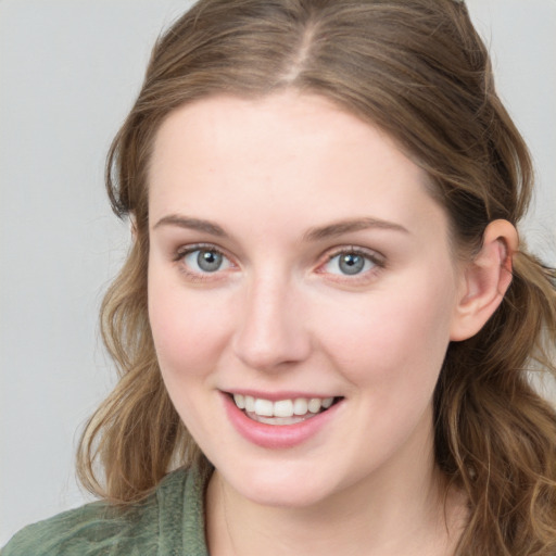 Joyful white young-adult female with long  brown hair and blue eyes