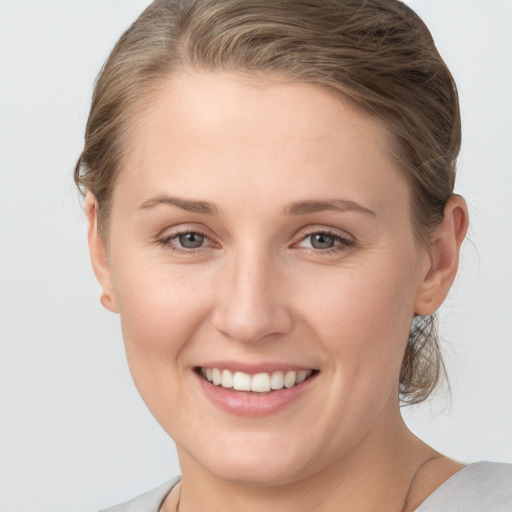 Joyful white young-adult female with short  brown hair and grey eyes