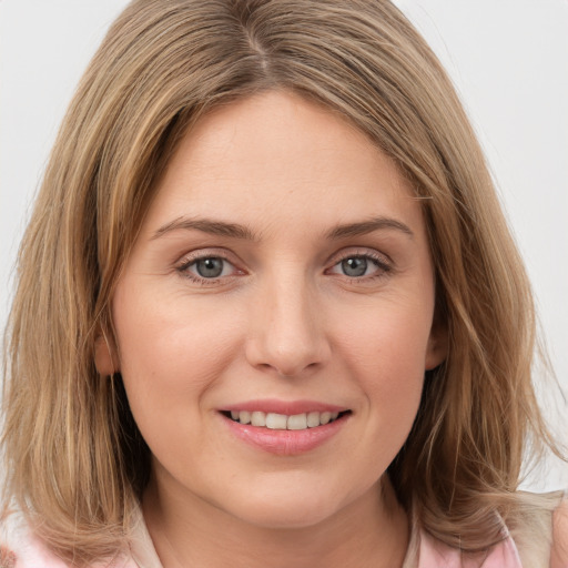 Joyful white young-adult female with medium  brown hair and green eyes