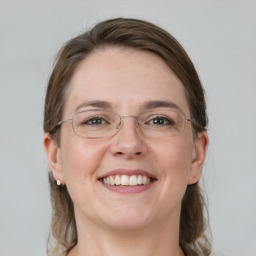 Joyful white adult female with medium  brown hair and grey eyes