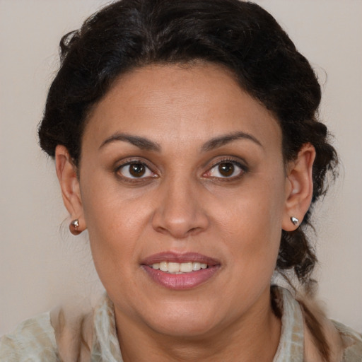 Joyful latino adult female with medium  brown hair and brown eyes