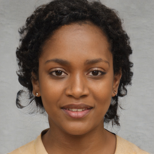 Joyful black young-adult female with medium  black hair and brown eyes