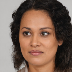 Joyful latino young-adult female with medium  brown hair and brown eyes