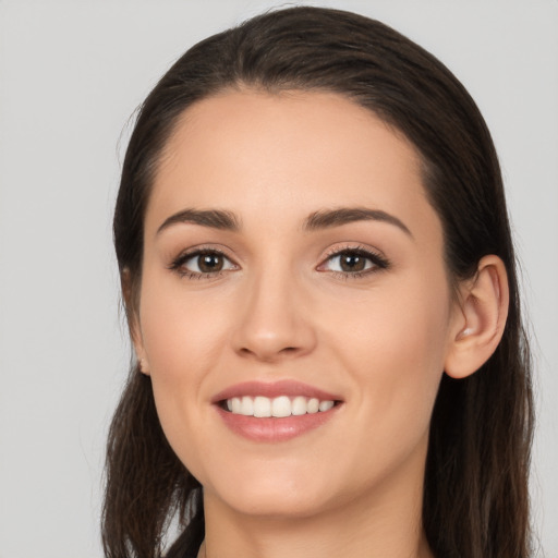 Joyful white young-adult female with long  brown hair and brown eyes