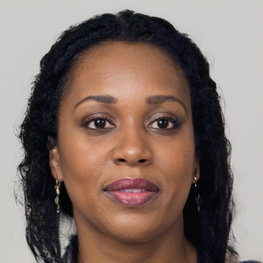 Joyful black adult female with long  black hair and brown eyes