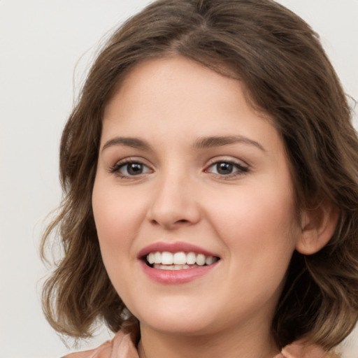 Joyful white young-adult female with medium  brown hair and green eyes