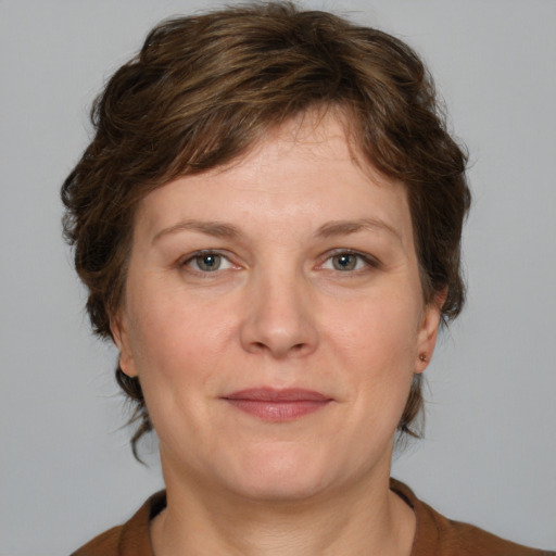 Joyful white adult female with medium  brown hair and grey eyes