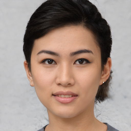 Joyful asian young-adult female with short  black hair and brown eyes