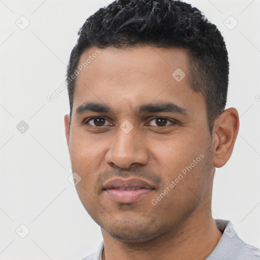 Joyful latino young-adult male with short  black hair and brown eyes