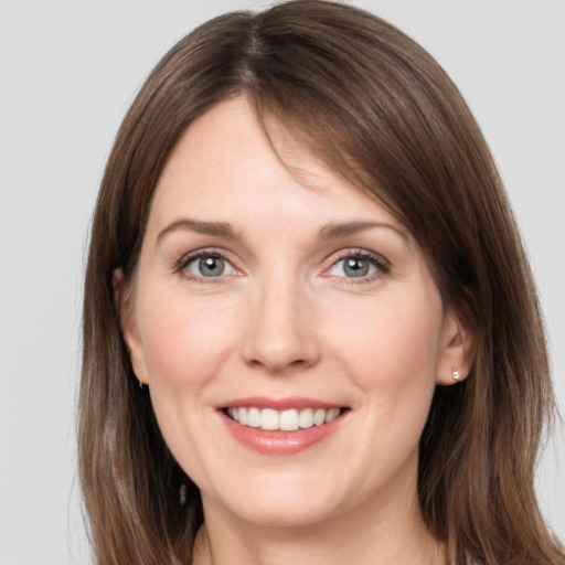 Joyful white young-adult female with medium  brown hair and grey eyes