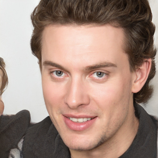 Joyful white young-adult male with short  brown hair and blue eyes