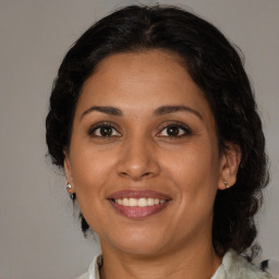 Joyful latino adult female with medium  brown hair and brown eyes