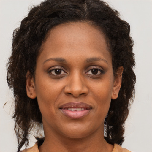 Joyful black young-adult female with medium  brown hair and brown eyes