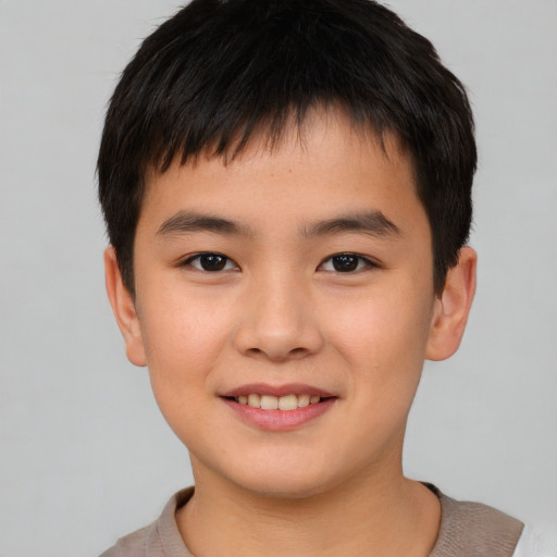 Joyful asian child male with short  brown hair and brown eyes