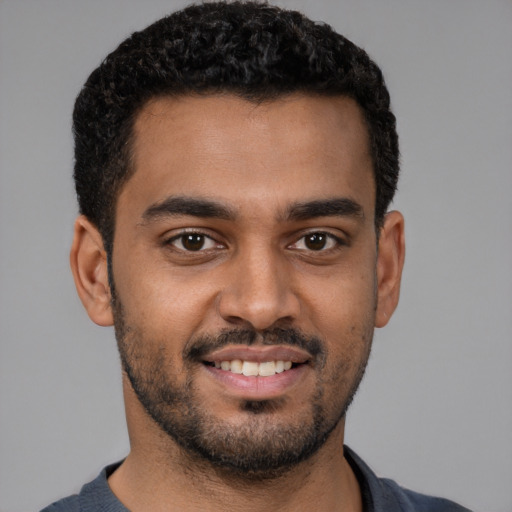 Joyful black young-adult male with short  black hair and brown eyes