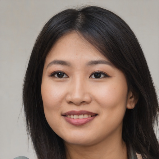 Joyful asian young-adult female with long  brown hair and brown eyes