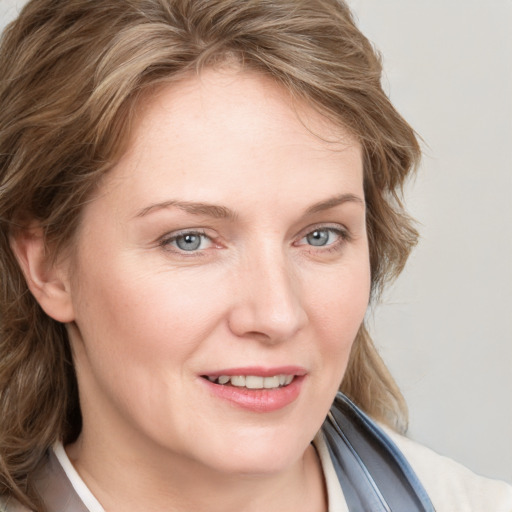 Joyful white young-adult female with medium  brown hair and blue eyes