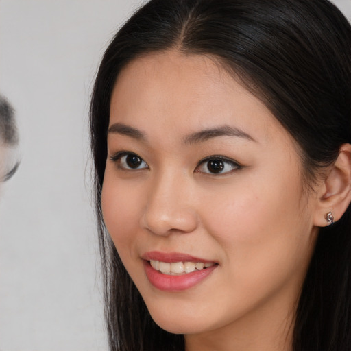 Joyful asian young-adult female with long  brown hair and brown eyes