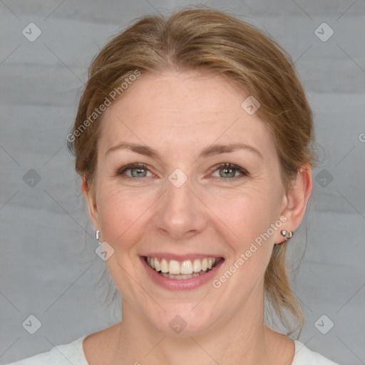 Joyful white adult female with medium  brown hair and blue eyes