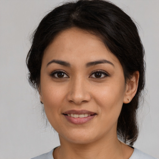 Joyful latino young-adult female with medium  brown hair and brown eyes