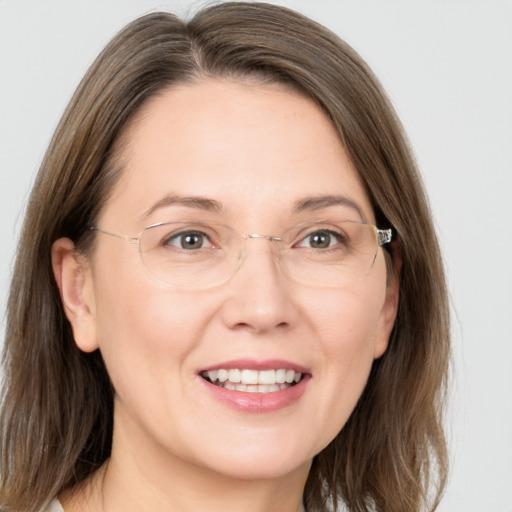 Joyful white adult female with medium  brown hair and grey eyes