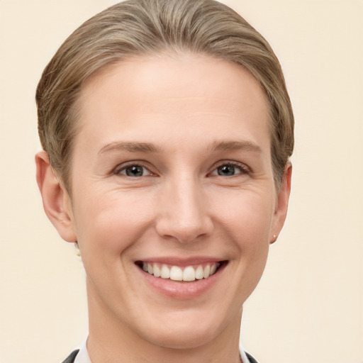 Joyful white young-adult female with short  brown hair and grey eyes