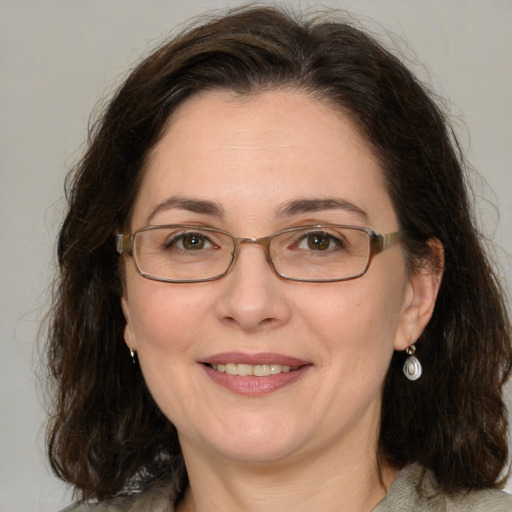 Joyful white adult female with medium  brown hair and green eyes