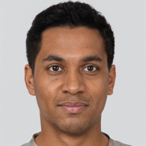 Joyful black young-adult male with short  black hair and brown eyes