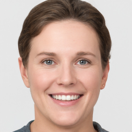 Joyful white young-adult female with short  brown hair and grey eyes