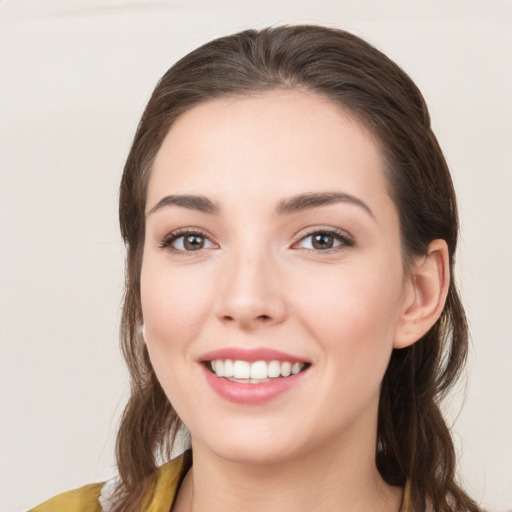 Joyful white young-adult female with long  brown hair and brown eyes