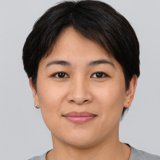 Joyful asian young-adult female with short  brown hair and brown eyes