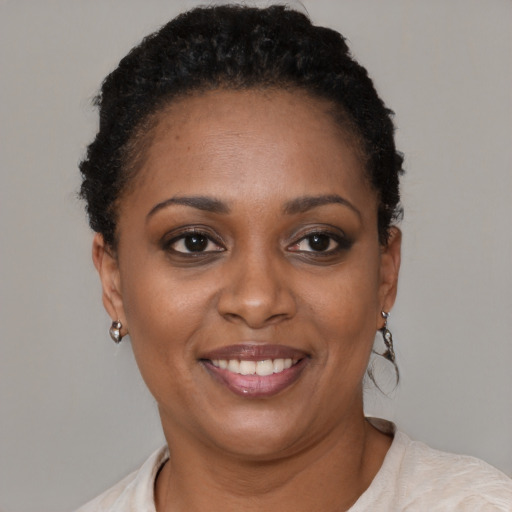 Joyful black young-adult female with short  brown hair and brown eyes
