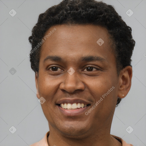 Joyful black young-adult male with short  black hair and brown eyes