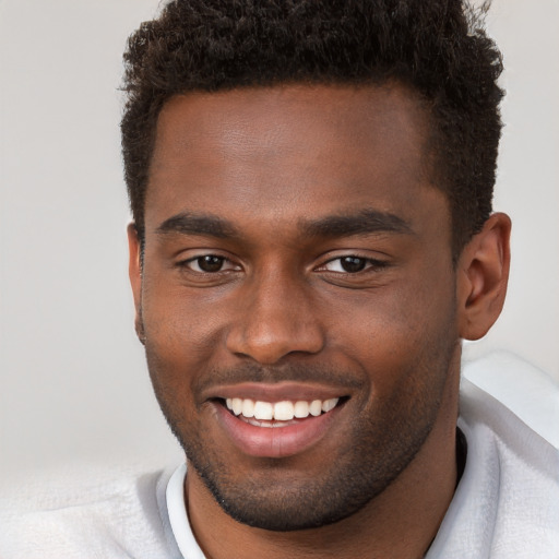 Joyful black young-adult male with short  brown hair and brown eyes