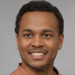 Joyful latino young-adult male with short  brown hair and brown eyes