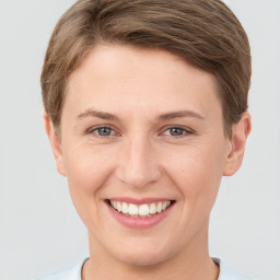 Joyful white young-adult female with short  brown hair and grey eyes