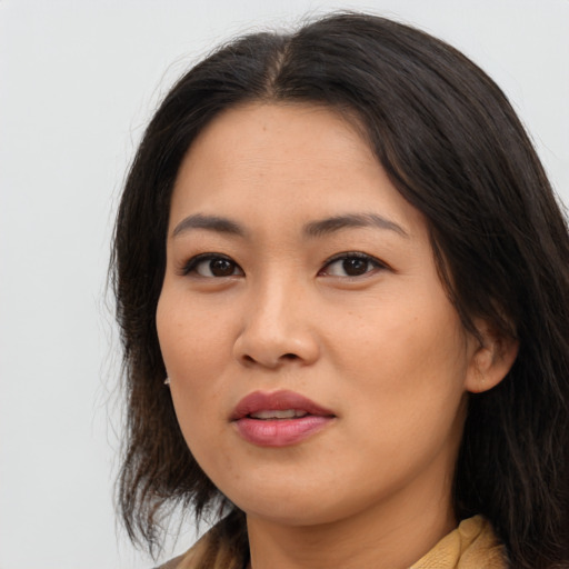 Joyful asian young-adult female with long  brown hair and brown eyes