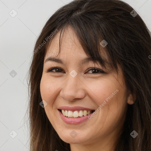 Joyful white adult female with long  brown hair and brown eyes