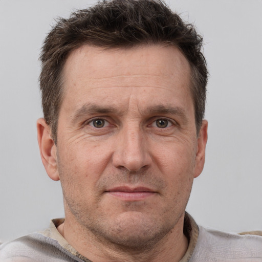 Joyful white adult male with short  brown hair and grey eyes