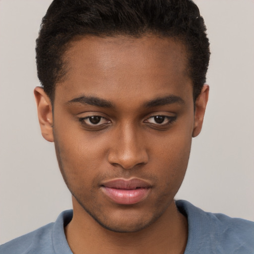 Joyful black young-adult male with short  brown hair and brown eyes