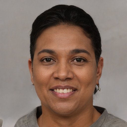 Joyful latino adult female with short  black hair and brown eyes